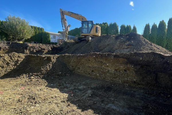 An excavator on a job site in Vernon BC excavating dirt for Platinum Ridge Earthworks